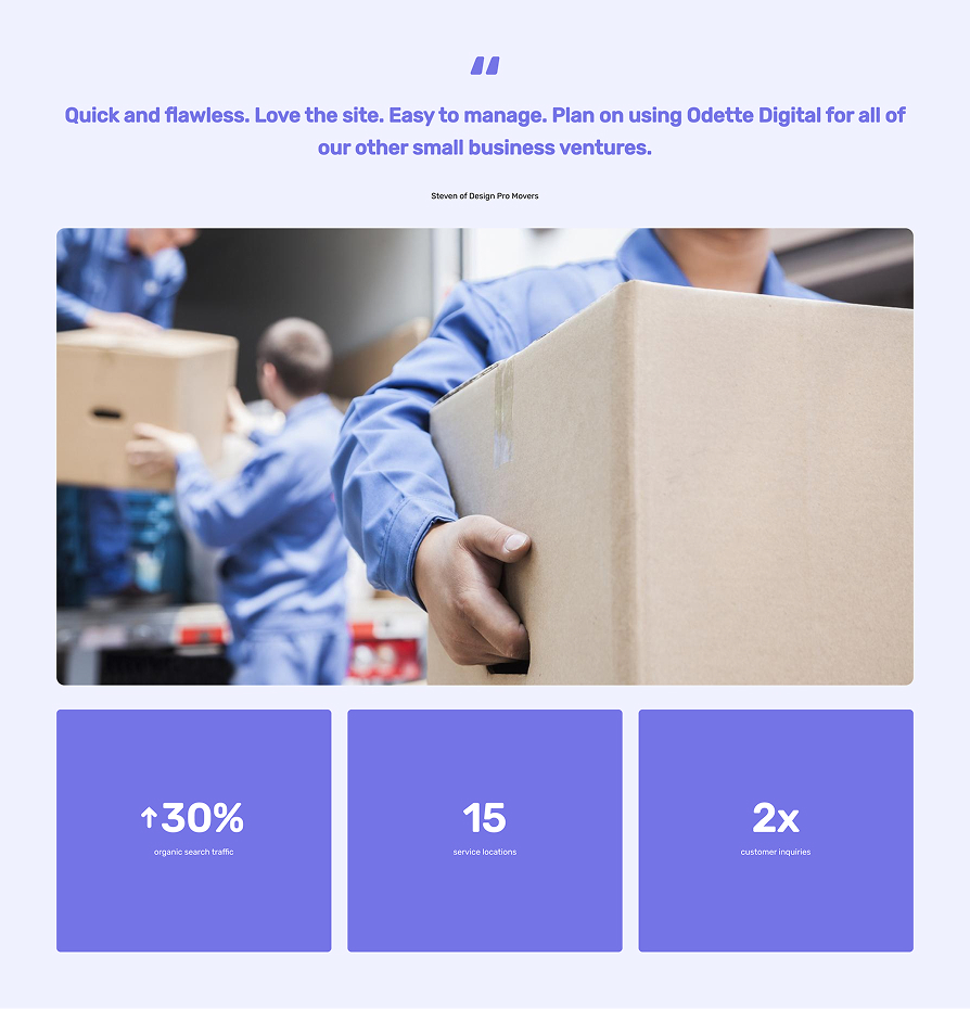 Worker in blue uniform holding a large cardboard box with blurred coworkers handling boxes in the background.